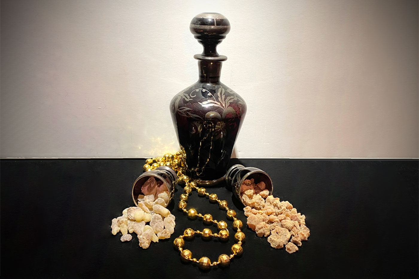 bottle with gold beads and chunks coming from two cups on each side